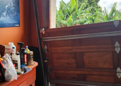 Technicians adjusting a wall-mounted garage door motor unit. - Bedfordview Garage Door Repairs | Your Garage Door Guy Technicians adjusting a wall-mounted garage door motor unit.